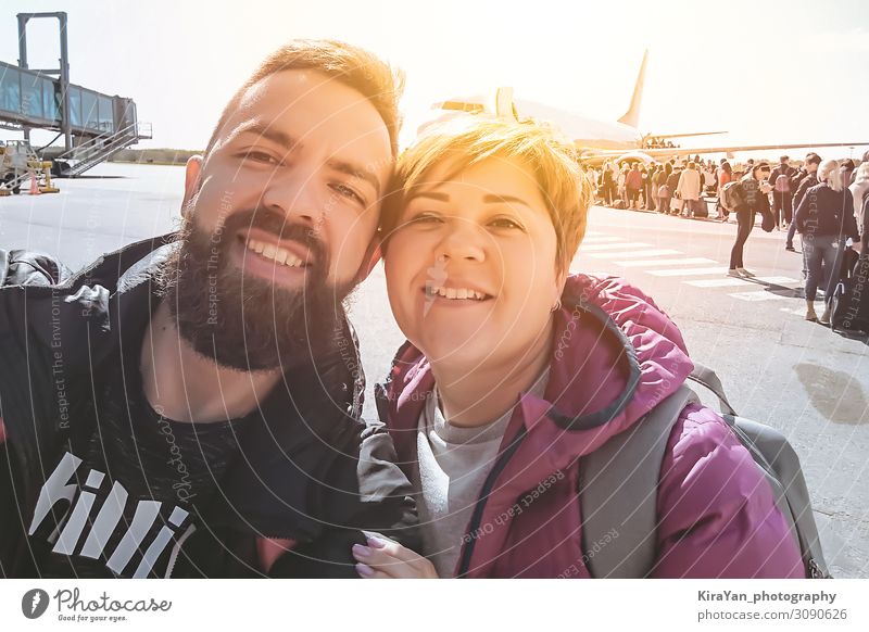 Lächelndes tausendjähriges Paar, das sich bei Flughafenabflügen selbstständig macht Lifestyle Glück schön Gesicht Ferien & Urlaub & Reisen Tourismus Ausflug
