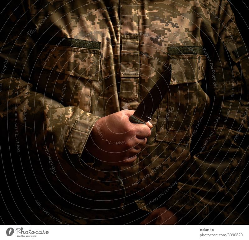 Soldat in Militäruniform hält ein scharfes taktisches Messer. Mann Erwachsene Hand grün schwarz Kraft Gewalt Halt Uniform Ukrainer stechend Verteidigung