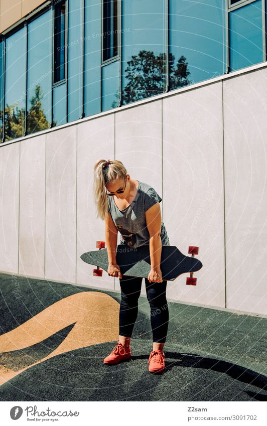Skaterin Lifestyle elegant Stil Freizeit & Hobby Sommer Skateboarding Longboard Junge Frau Jugendliche Stadt Hochhaus T-Shirt Jeanshose Sonnenbrille Turnschuh