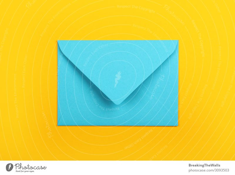Geschlossener blauer Papierumschlag über gelbem Hintergrund Büro Post Schreibwaren modern oben Farbe Kreativität Pastell Beitrag Mitteilung blanko leer flach