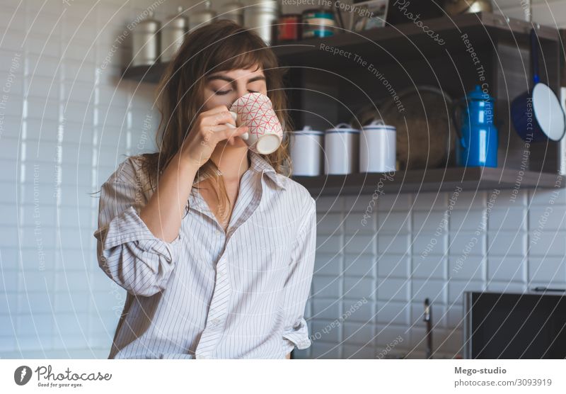 junge Frau, die zu Hause Kaffee trinkt Frühstück Getränk Tee Lifestyle Glück schön Gesicht Erholung Freizeit & Hobby Tisch Küche Mensch Erwachsene Wärme