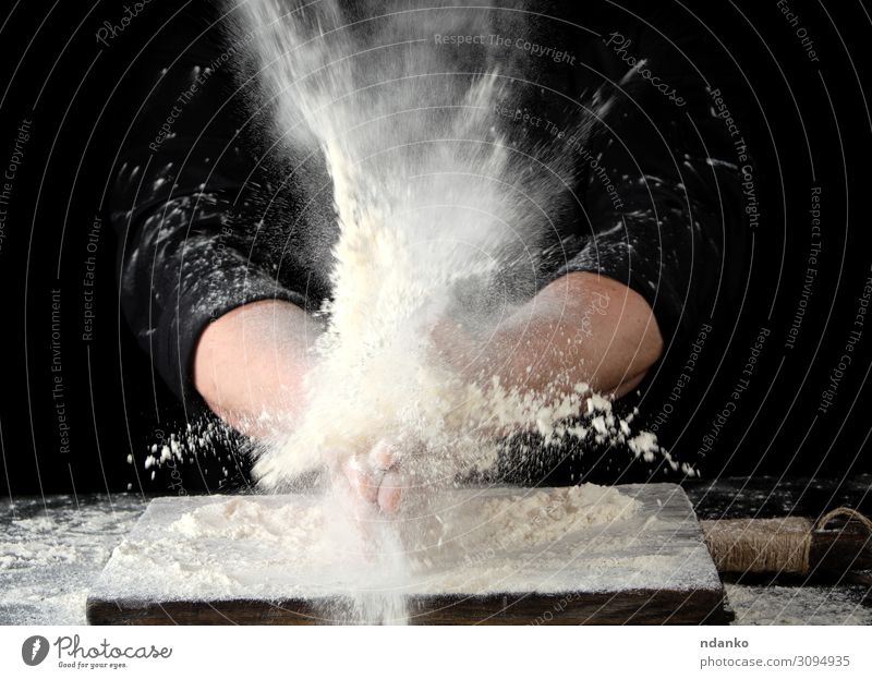 Chefkoch in schwarzer Uniform Streusel weißes Weizenmehl Teigwaren Backwaren Brot Ernährung Körper Tisch Küche Mensch Mann Erwachsene Hand Wolken Bewegung