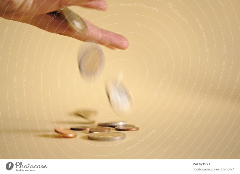 Geldmünzen fallen zwischen Fingern einer Hand hindurch. Armut Inflation Wert Mensch Hemmungslosigkeit verschwenden Gesellschaft (Soziologie) Risiko