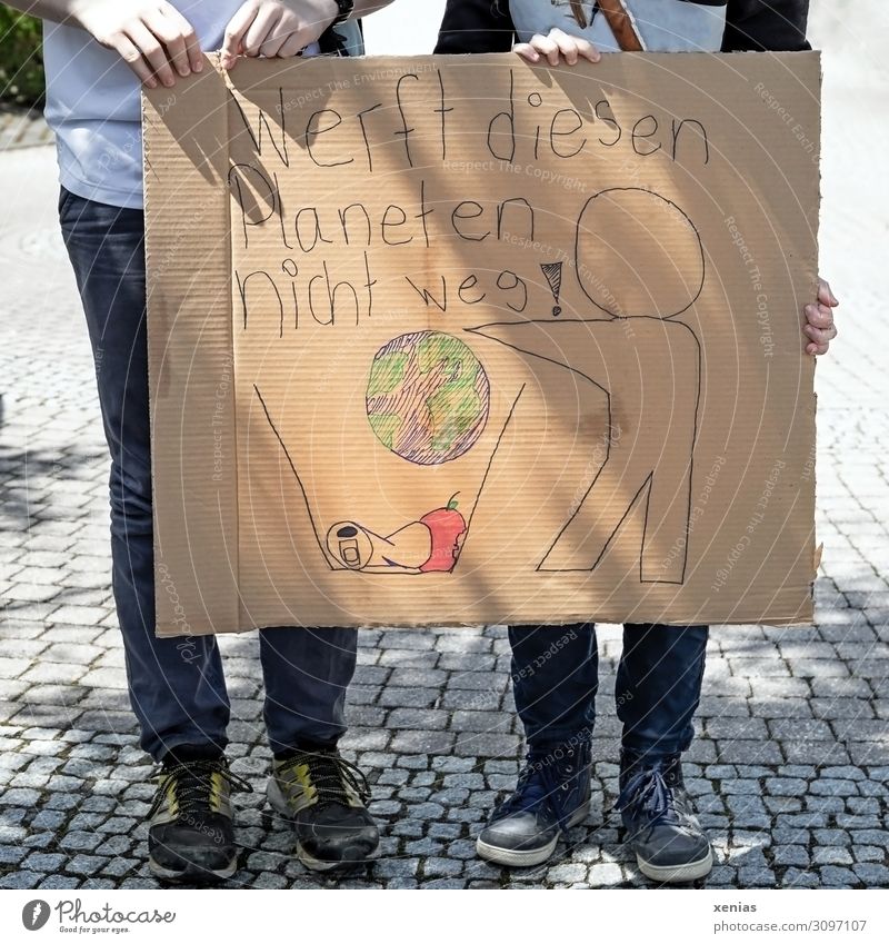 wertvoll / Werft diesen Planeten nicht weg! Zwei Jugendliche stehen auf der Straße und halten bemalten Karton in den Händen für Demonstration Klima