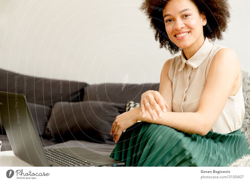 Junge afroamerikanische Frau, die im Internet surft. Lifestyle Glück schön Freizeit & Hobby Sofa Computer Notebook Technik & Technologie Telekommunikation