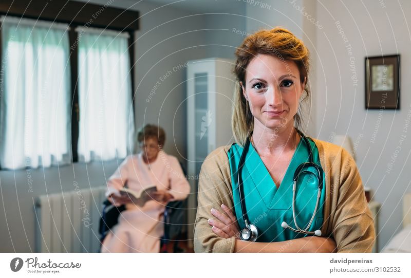 Hübsche Ärztin in einer geriatrischen Klinik mit einer älteren Frau im Rollstuhl schön Gesundheitswesen Krankheit Erholung lesen Schlafzimmer Arzt Krankenhaus