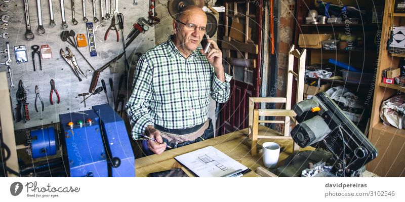 Schreiner in seiner Werkstatt Stuhl Handwerk Business sprechen Internet Mensch Mann Erwachsene Holz alt authentisch Schreinerei Zimmerer Mobile Senior