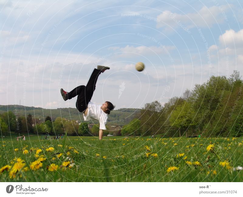 Kick it Hand zurückziehen Wiese extrem Farblosigkeit Sport Fußball Breakdancer Ball in der Luft Himmel Schmerz