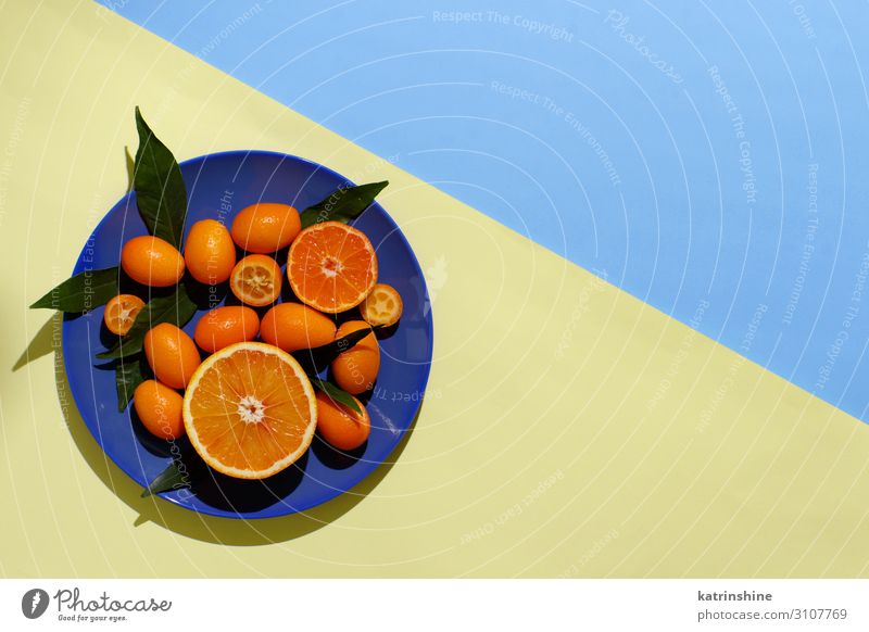 Zitrusfrüchte auf gelbem und blauem Hintergrund Frucht Ernährung Vegetarische Ernährung Diät Teller exotisch Sommer Menschengruppe Blatt frisch modern natürlich