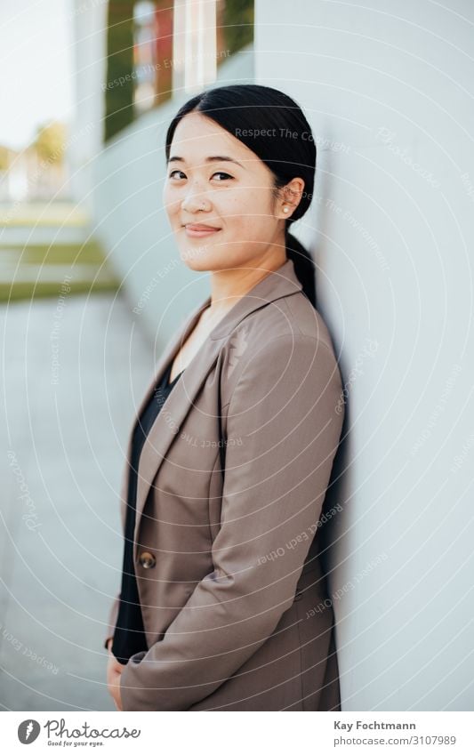 Lächelnde asiatische Geschäftsfrau an Wand gelehnt Asien attraktiv schön Schönheit Blazer Business Karriere charmant heiter Chinesisch selbstbewusst Berater