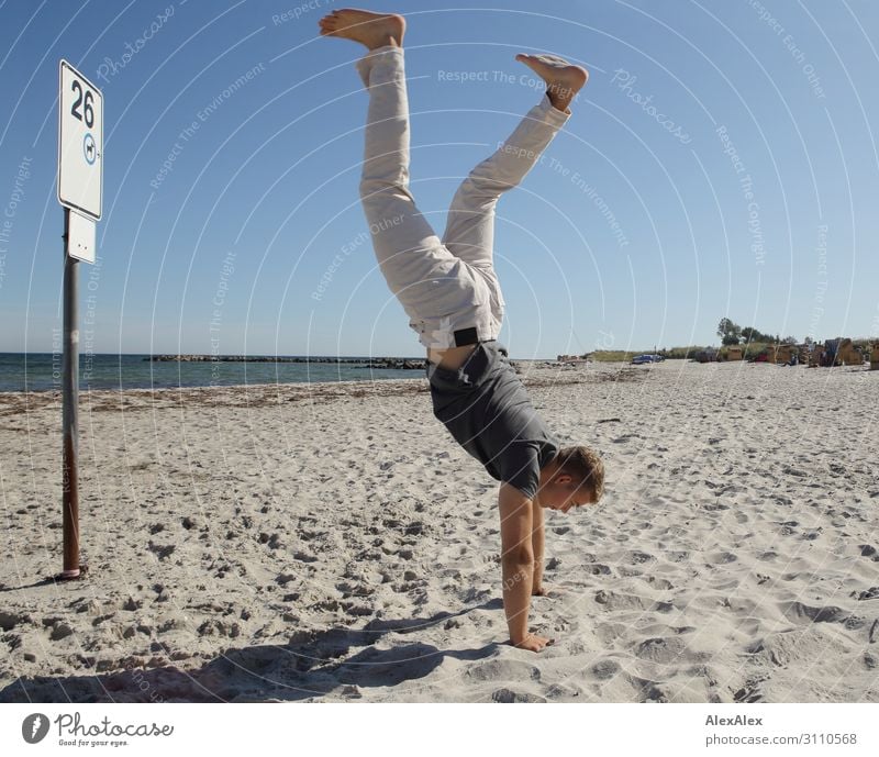Junger, sportlicher Mann macht Handstand ein einem Strand Lifestyle Stil Freude schön Fitness Leben Sommer Sommerurlaub Sonne Meer Leichtathletik Junger Mann