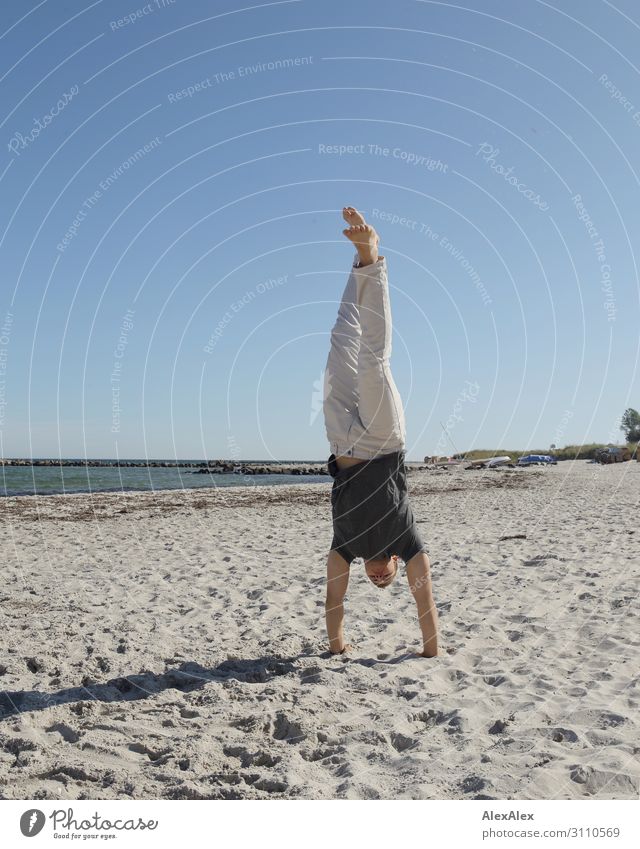 Junger, sportlicher Mann macht Handstand am Ostseestrand Lifestyle Freude Fitness Leben Sommer Sommerurlaub Strand Meer Leichtathletik Junger Mann Jugendliche