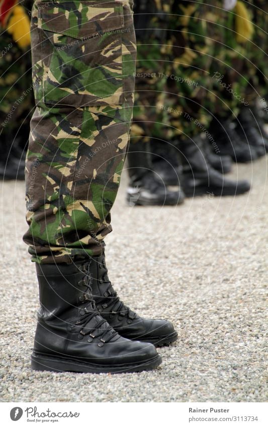Beine eines Soldaten in Uniform mit Tarnfarben während einer Zeremonie. Im Hintergrund weitere Soldaten. Militär maskulin Mann Erwachsene Fuß 18-30 Jahre