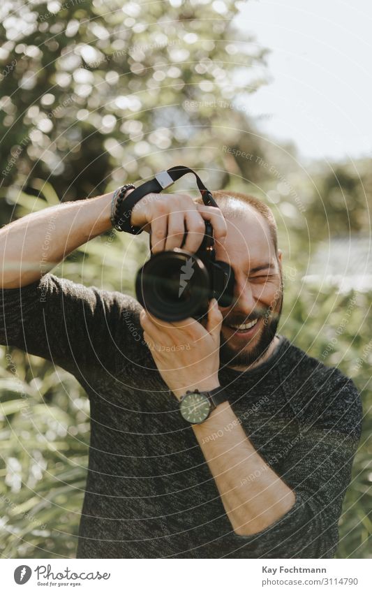 Glücklicher Fotograf macht ein Foto Vollbart Fotokamera Kaukasier digital Gerät Spaß grün Lifestyle Mann Männer Natur Naturfotografie im Freien Menschen Person