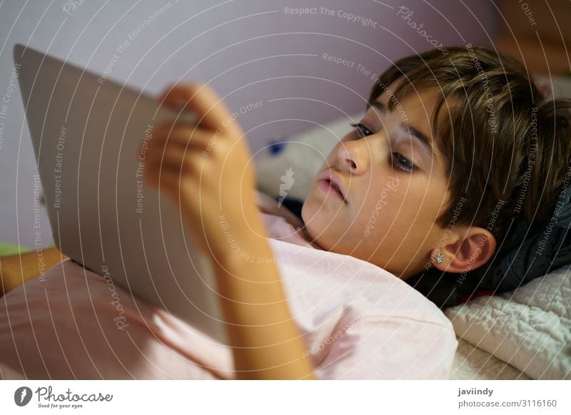 Süßes Mädchen, das einen Tablet-Computer in ihrem Schlafzimmer benutzt. Lifestyle Freude Glück schön Gesicht Freizeit & Hobby Spielen Kind Schule