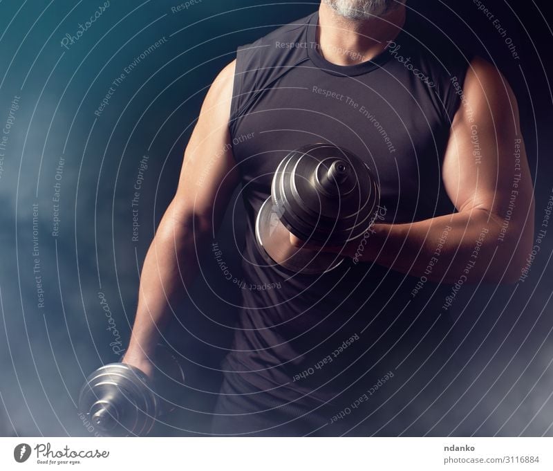 Mann in schwarzer Kleidung hält Stahlhanteln. Lifestyle sportlich Fitness Sport Sportler Erwachsene Hand 1 Mensch 30-45 Jahre stehen muskulös stark Kraft Macht