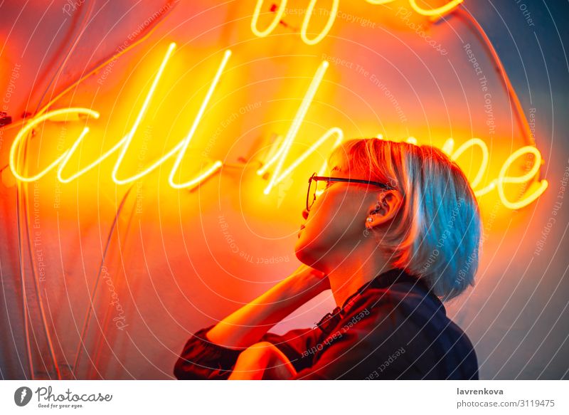 Brillenträgerinnen vor dem Neonlichtschild Asiate blond Frau Junge Frau Mädchen Beleuchtung Licht Nachtleben orange Porträt rot kurzhaarig Kurzhaarschnitt