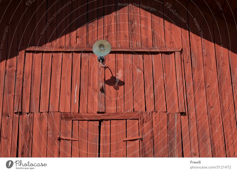 rot gestrichene Scheunenwand Wand Holz Holzstruktur Bretter genagelt schwedenrot alt verwittert Tür Riegel Lampe Schatten Licht Sonnenlicht Gebäude Schweden