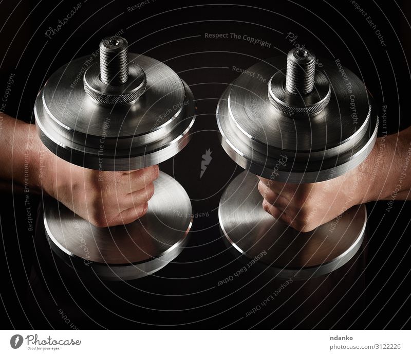 zwei Stahlsatzhanteln in männlichen Händen Lifestyle Sport Sportler Hand Metall Fitness muskulös schwarz Kraft Kurzhantel Sporthalle Gewichte Bodybuilding