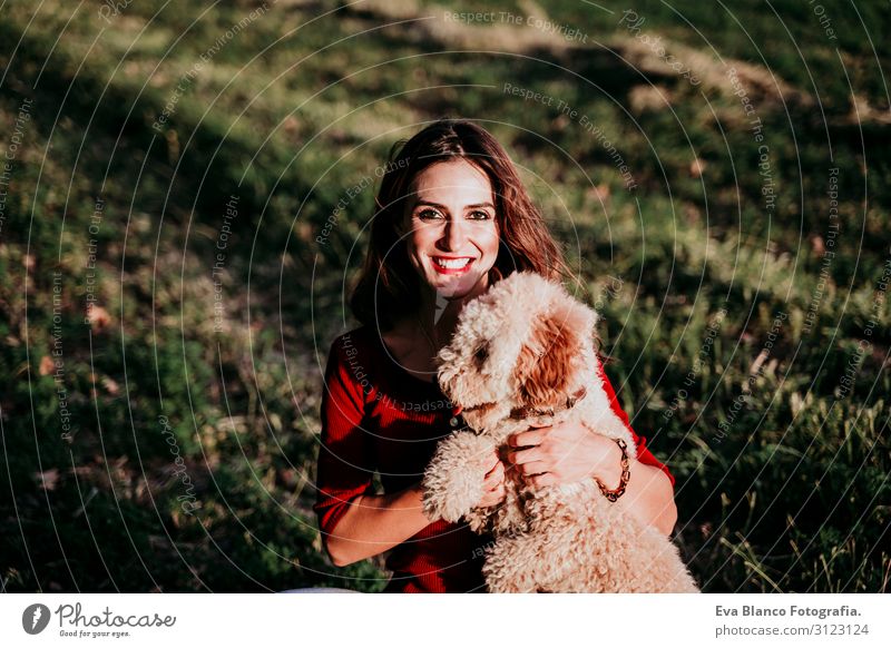 schöne kaukasische Frau mit ihrem süßen braunen Pudelhund bei Sonnenuntergang auf dem Land. Haustiere und Lebensweise im Freien Jugendliche Feld Hut Lifestyle
