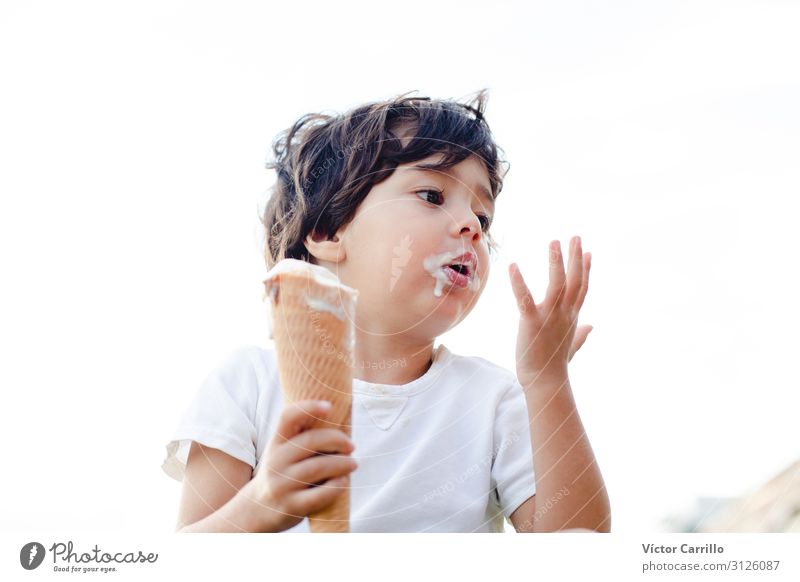 Ein kleiner Junge isst ein Eis. Lifestyle Mensch Kind Kleinkind 1 1-3 Jahre authentisch natürlich niedlich Originalität positiv Außenaufnahme Textfreiraum links