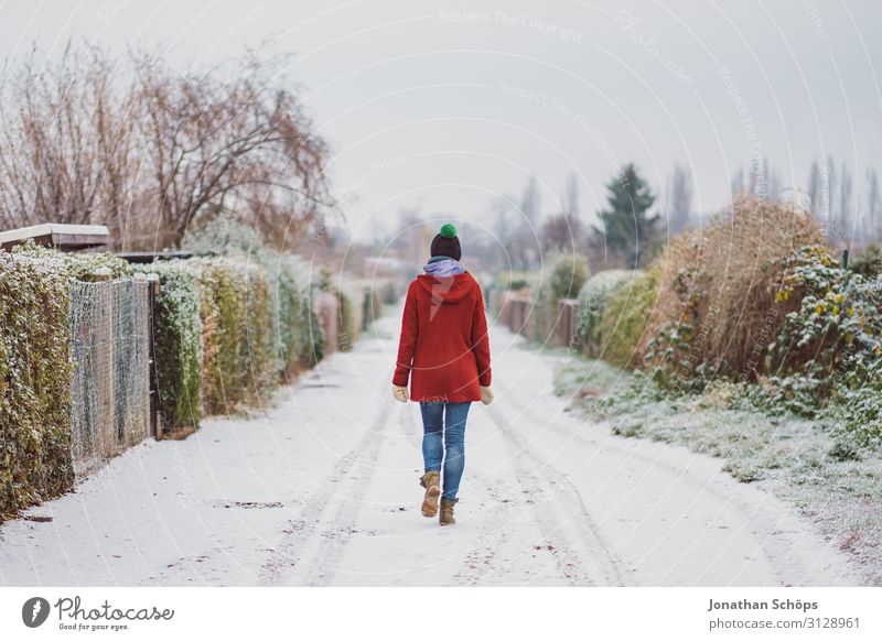 Weitwinkel Winterlandschaft mit Frau im roten Mantel 18-30 Jahre Straße Einsamkeit einzeln kalt Freiheit gefroren Garten Jacke Jeanshose Außenaufnahme