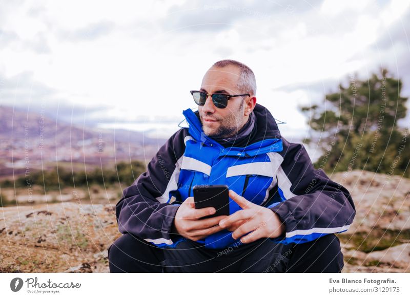 junger Wanderer mit Smartphone auf dem Gipfel des Berges. bewölkter Tag Bildschirm intelligente Uhr wandern App ultra Training Fitness Lifestyle üben Gerät