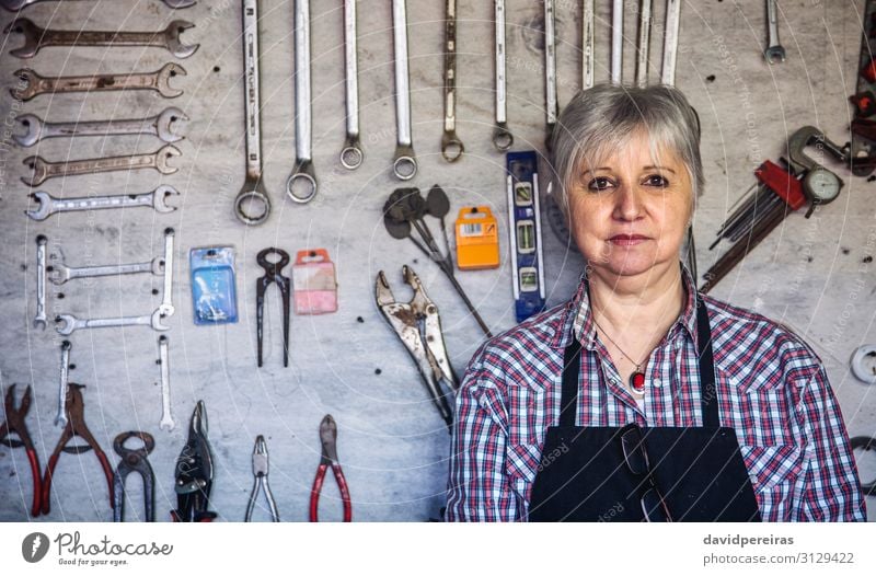 Weiblicher Tischler posiert mit verschränkten Armen in seiner Werkstatt Handwerk Business Mensch Frau Erwachsene alt authentisch Zimmerer reif Werkzeugtafel