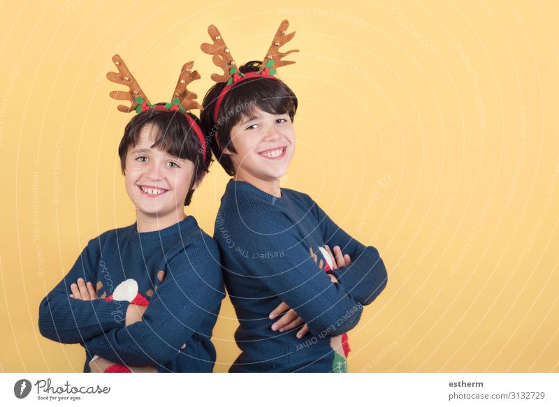 lächelnde Kinder in einem Rudolph-Rentier-Weihnachtskostüm auf gelbem Hintergrund Freude Winter Feste & Feiern Weihnachten & Advent Silvester u. Neujahr Mensch