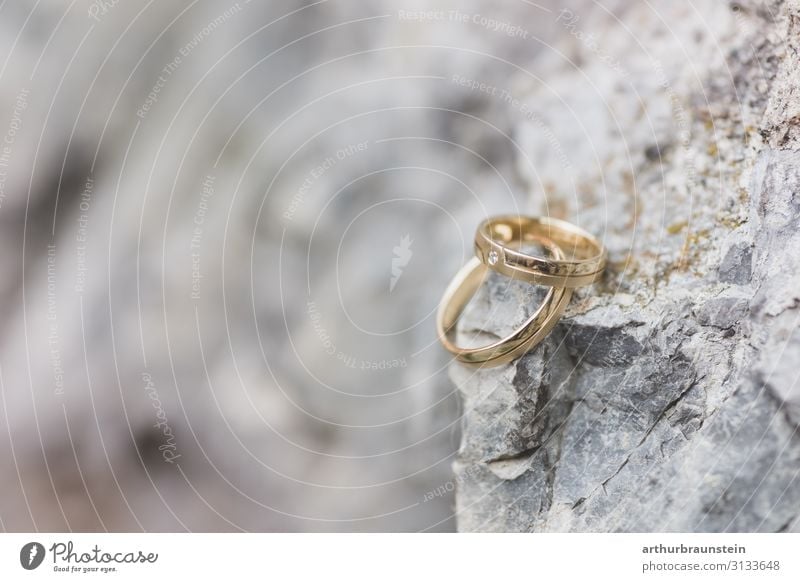 Goldene Eheringe auf einem Fels Lifestyle kaufen elegant Glück Hochzeit Felsen Steinmauer steinig Ring Edelstein Frühlingsgefühle Vertrauen Verliebtheit