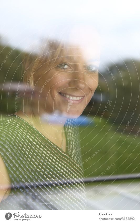 Portrait einer jungen Frau hinter einem Fenster Lifestyle elegant Stil Freude schön harmonisch Häusliches Leben Garten Glasscheibe Junge Frau Jugendliche