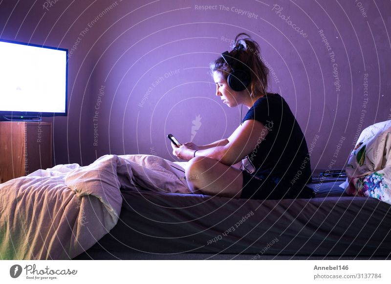 Junge Frau, die nachts im Bett einen Film im Fernsehen schaut. Lifestyle Freude Glück schön Freizeit & Hobby Schlafzimmer Entertainment Telefon Handy Bildschirm