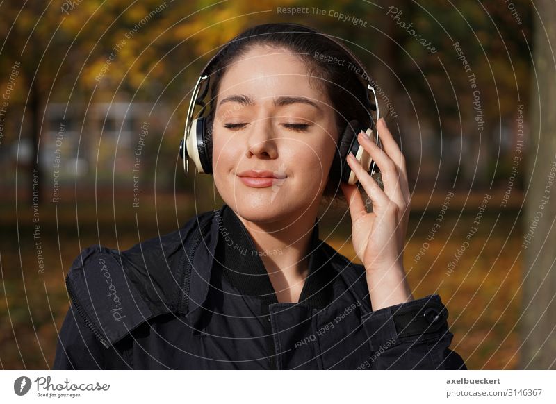 junge Frau hört draussen Musik über Kopfhörer Lifestyle Freude Freizeit & Hobby Entertainment Technik & Technologie Unterhaltungselektronik Mensch feminin