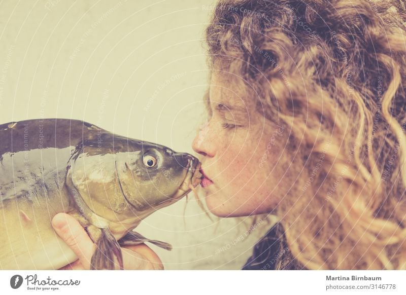 Junge Frau, die einen Karpfen küsst, Fisch. Meeresfrüchte Abendessen Diät Lifestyle Glück schön Gesicht Mensch feminin Erwachsene Mund Lippen Tier Küssen Liebe