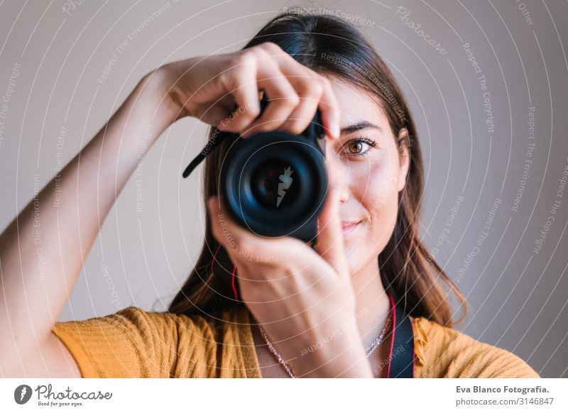 Fotografin zu Hause, die eine Kamera hält. Technologie und Lebensstil in Innenräumen Kaukasier Frau Jugendliche Fotokamera reflektorisch Technik & Technologie