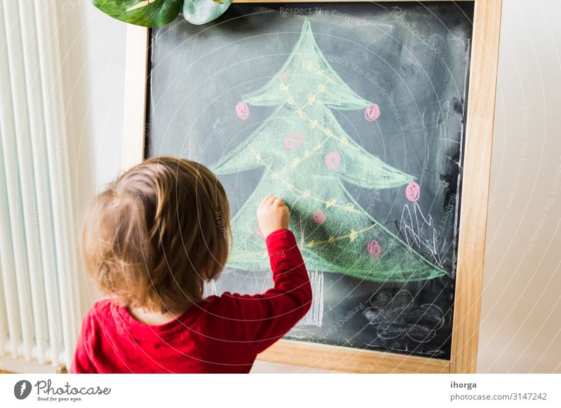Ein Kind malt einen Weihnachtsbaum auf eine Tafel Lifestyle Freude schön Winter Winterurlaub Feste & Feiern Weihnachten & Advent Mensch Baby Junge Freundschaft