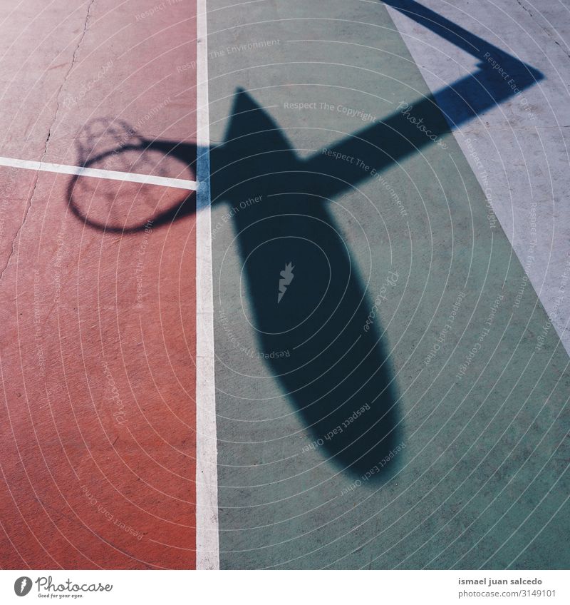 Basketballkorb Schattensilhouette auf dem roten Feld Korb Reifen Silhouette Sonnenlicht Boden Gerichtsgebäude Spielfeld Etage Sport Spielen aussetzen Straße