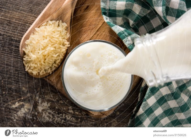 Reismilch in Glas auf Holztisch gießen. Draufsicht Milch Wasser Getränk Kalzium Flüssigkeit liquide Lebensmittel Gesunde Ernährung Foodfotografie natürlich