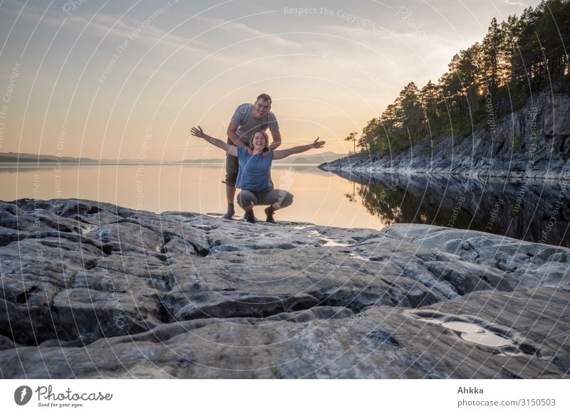 Junges Paar feiert nordische Landschaft vor Sonnenuntergang Skandinavien Harmonie Freude Glück Natur Naturliebe Frieden Wildnis See Felsen stimmungsvoll Ruhe
