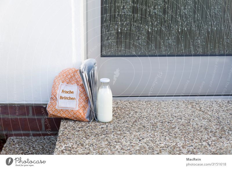 Das Frühstück vor der Haustür Brötchen Milch Flasche Zeitung Zeitschrift Gesundheit Pünktlichkeit Eingangstür Glasflasche tüte service Textfreiraum Farbfoto