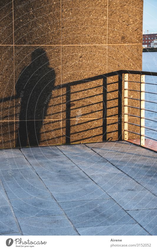 auf der Schattenseite | UT Hamburg 1 Mensch Fassade Geländer Bodenplatten Straßenbelag Plattform Platz stehen warten blau braun schwarz standhaft anlehnen