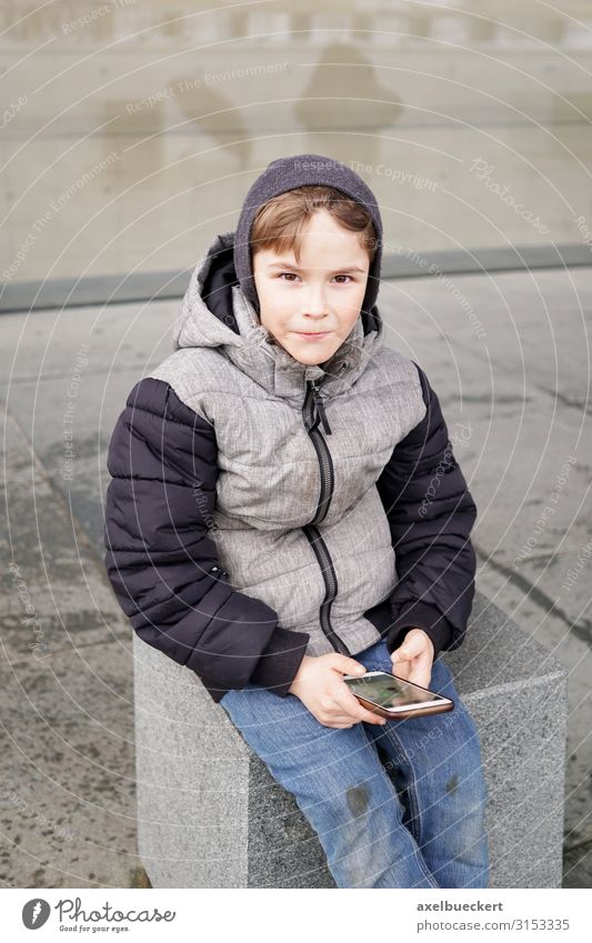 Junge mit Smartphone Lifestyle Freizeit & Hobby Spielen Winter Kind Schule Schulhof Telefon Handy PDA Technik & Technologie Internet Mensch Kindheit 1 3-8 Jahre