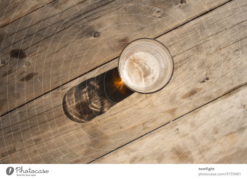 Feierabend Getränk Bier Glas trinken Holztisch Pause genießen Abendsonne ruhig Außenaufnahme Textfreiraum unten Licht Schatten Kontrast Sonnenlicht
