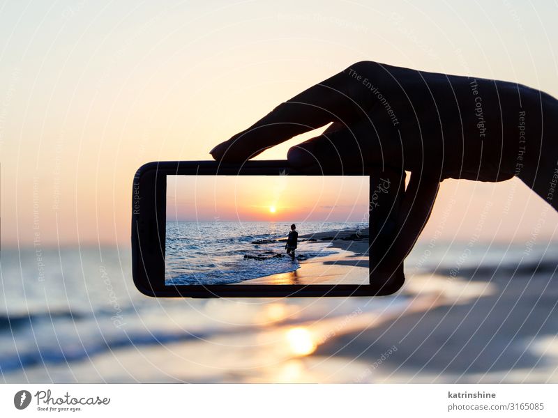 Der Mann macht ein Sonnenuntergangsfoto am Telefon. Ferien & Urlaub & Reisen Sommer Strand Meer Handy PDA Technik & Technologie Frau Erwachsene Umwelt Natur