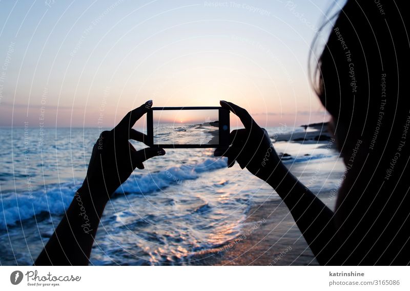 Das Mädchen macht ein Sonnenuntergangsfoto am Telefon. Ferien & Urlaub & Reisen Sommer Strand Meer Handy PDA Technik & Technologie Frau Erwachsene Umwelt Natur