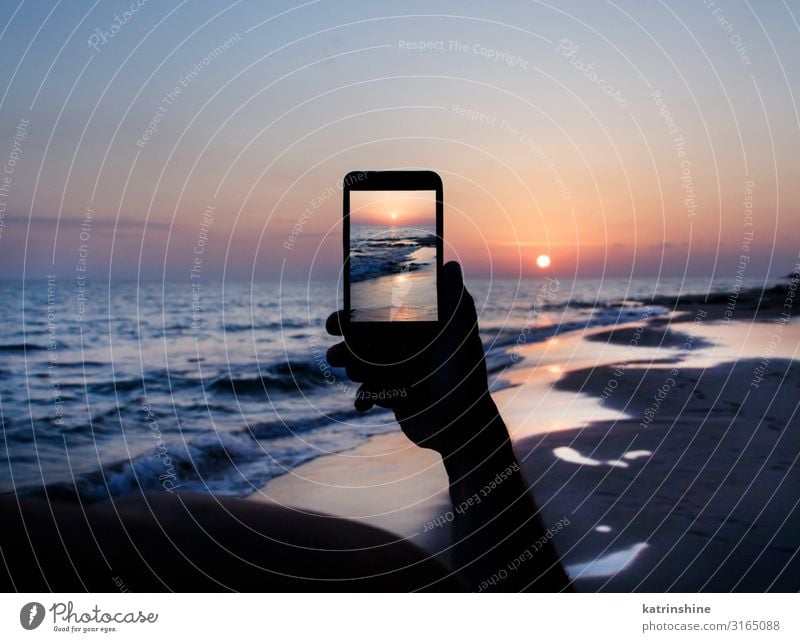 Der Mann macht ein Sonnenuntergangsfoto am Telefon. Ferien & Urlaub & Reisen Sommer Strand Meer Handy PDA Technik & Technologie Erwachsene Umwelt Natur