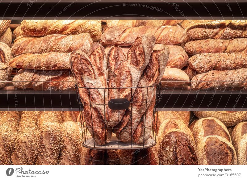 Lange Brotlaibe im Eisenkorb und Brotsortiment im Verkaufsregal Brötchen kaufen Gesunde Ernährung gelb Tradition Sortiment Backwaren Bäckerei Schwarzbrot
