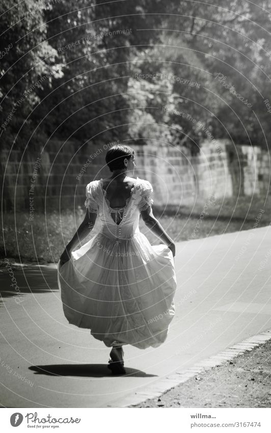 Frau in nostalgischem Brautkleid schreitet auf sonnigen Wegen, Rückansicht Hochzeit feminin Erwachsene Wege & Pfade langes Kleid kurzhaarig gehen lustig Freude