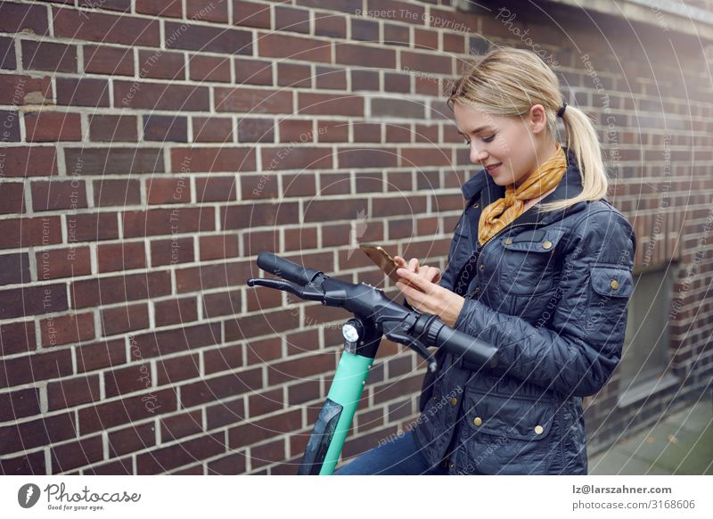 Trendige junge blonde Frau bucht E-Scooter Gesicht lesen PDA Technik & Technologie Erwachsene 1 Mensch 18-30 Jahre Jugendliche Umwelt Verkehr trendy Buchung