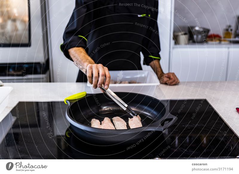 Chefkoch brät einen Barsch in einem Restaurant Lebensmittel Fleisch Fisch Meeresfrüchte Essen Mittagessen Abendessen Diät Pfanne Löffel Lifestyle Tisch Küche
